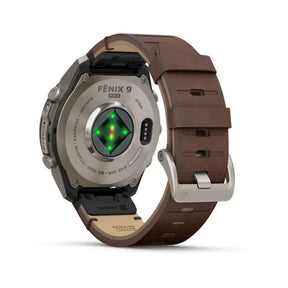Garmin Fenix 9 älykello takaapäin harmaalla titaanikotelolla ja pähkinänruskealla nahkarannekkeella sekä sykesensorilla