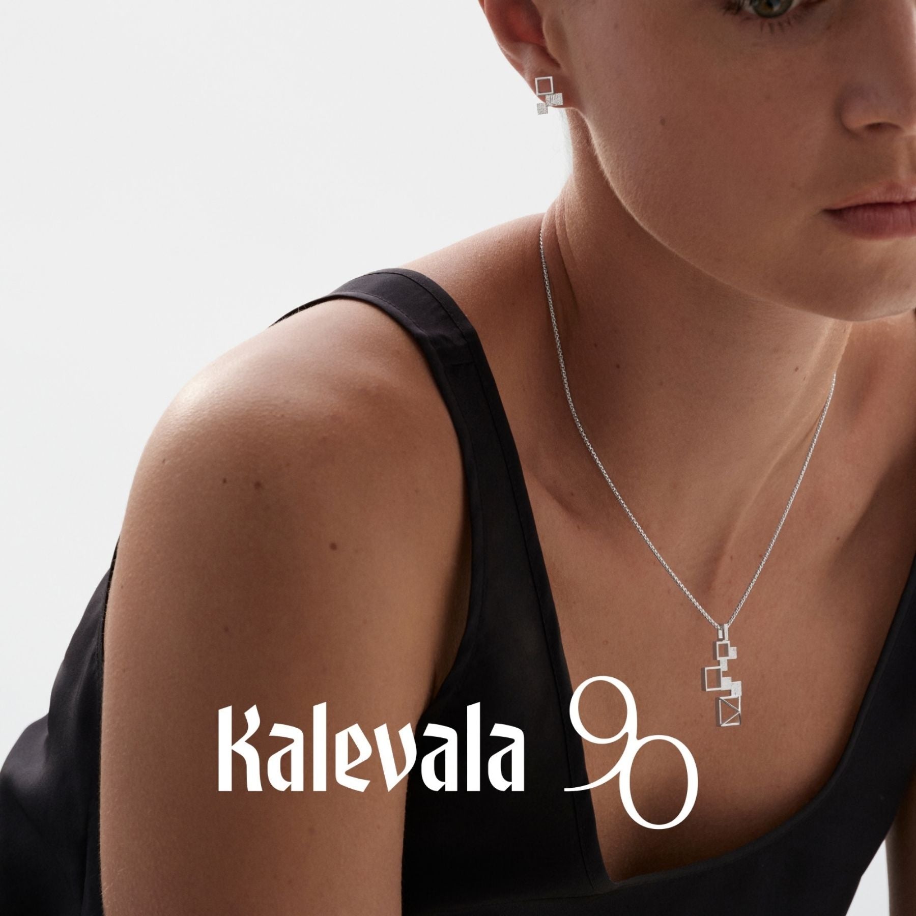 Kalevalan hopeinen Himmeli-riipus kaulaketjussa, geometriset neliöt muodostavat ilmavan riipuksen mustaa asua vasten