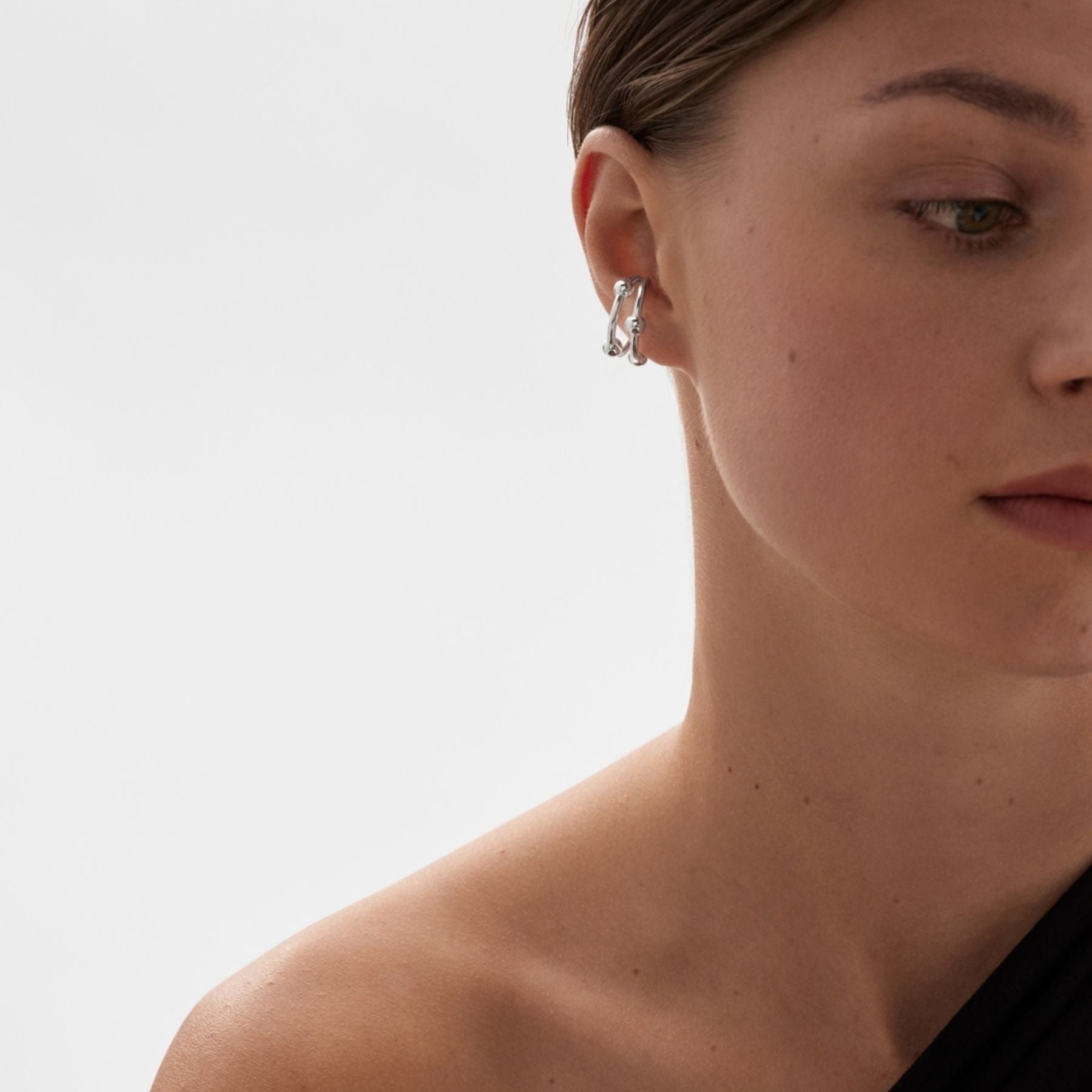 Kalevalan hopeinen Kehät ear cuff korvakoru mallin korvassa, avoin kaareva muoto ja pienet palloyksityiskohdat