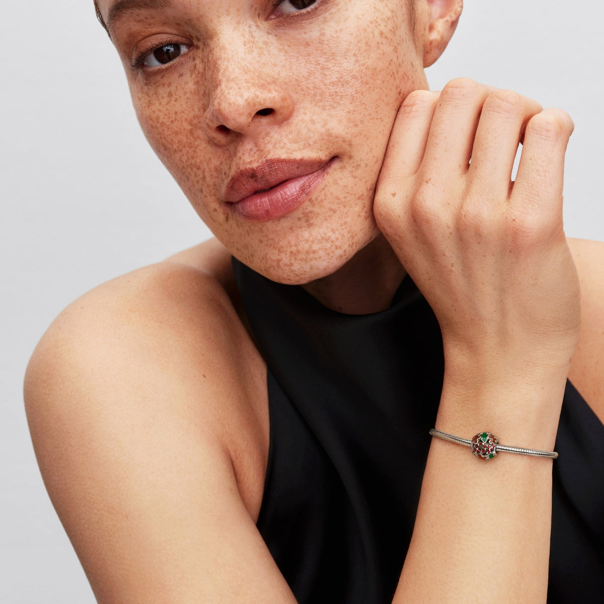 Pandora Moments platinapinnoitettu hela rannekorussa, jossa on värikäs jouluaiheinen emalikuviointi woman ranteessa