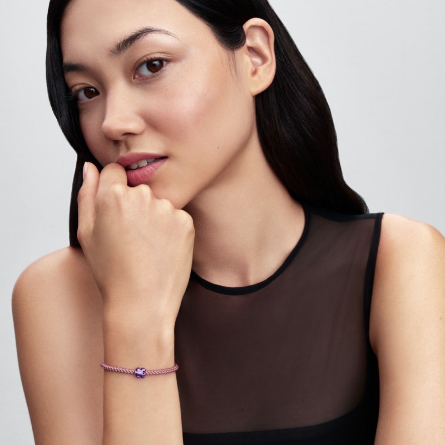 Pandora Moments rannekorussa näkyvä hopeinen palapelihela kiiltävällä violetilla emalilla mallin ranteessa