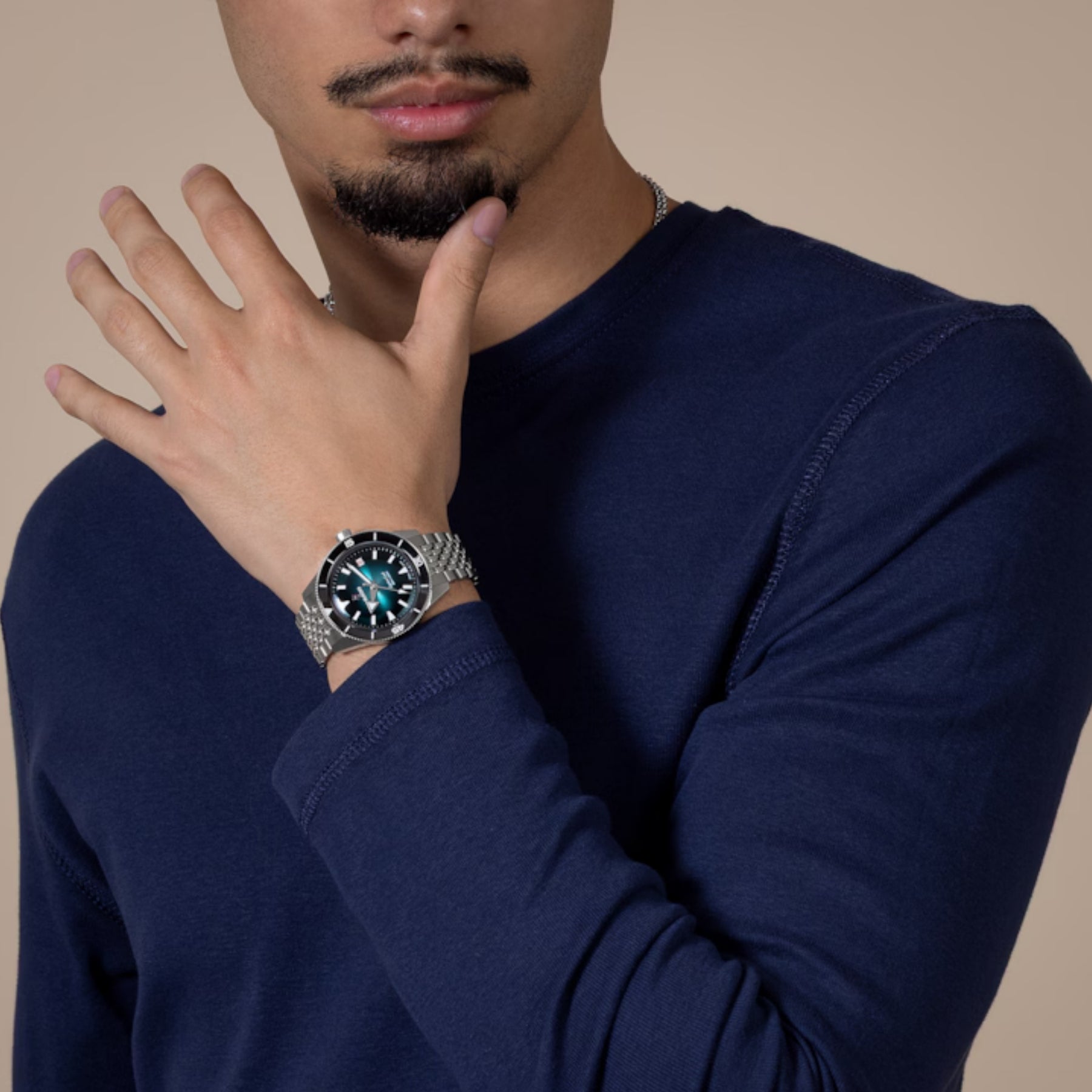 Rado rannekello miehen ranteessa, teräksenharmaa metalliranneke ja näyttävä mustaturkoosi kellotaulu.