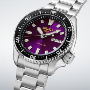 Seiko 5 Sports automaattinen rannekello violetilla taululla, teräsrannekkeella ja mustalla pyörivällä kehyksellä