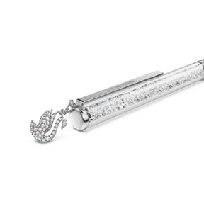 Swarovski-kynä kromipinnalla ja kirkkailla kristalleilla sekä koristeellisella joutsenriipuksella valkoisella taustalla