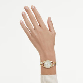 Swarovski keltakullattu bangle-rannekello kirkkailla kristalleilla ja vaalealla kellotaululla ranteessa