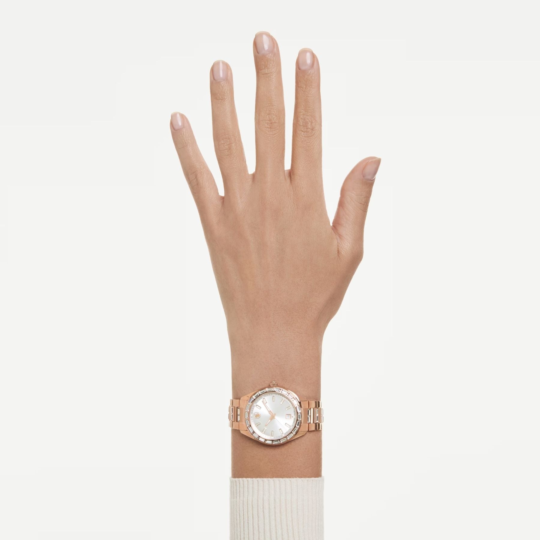 Swarovski ruusukultainen rannekello vaalealla kellotaululla ja kirkkailla kristalleilla ranteessa