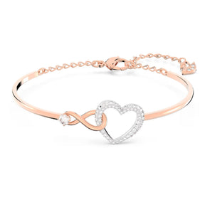 Swarovski rosekultainen rannekoru, jossa kristallikoristeinen sydän, ikuisuussymboli ja säätöketju.