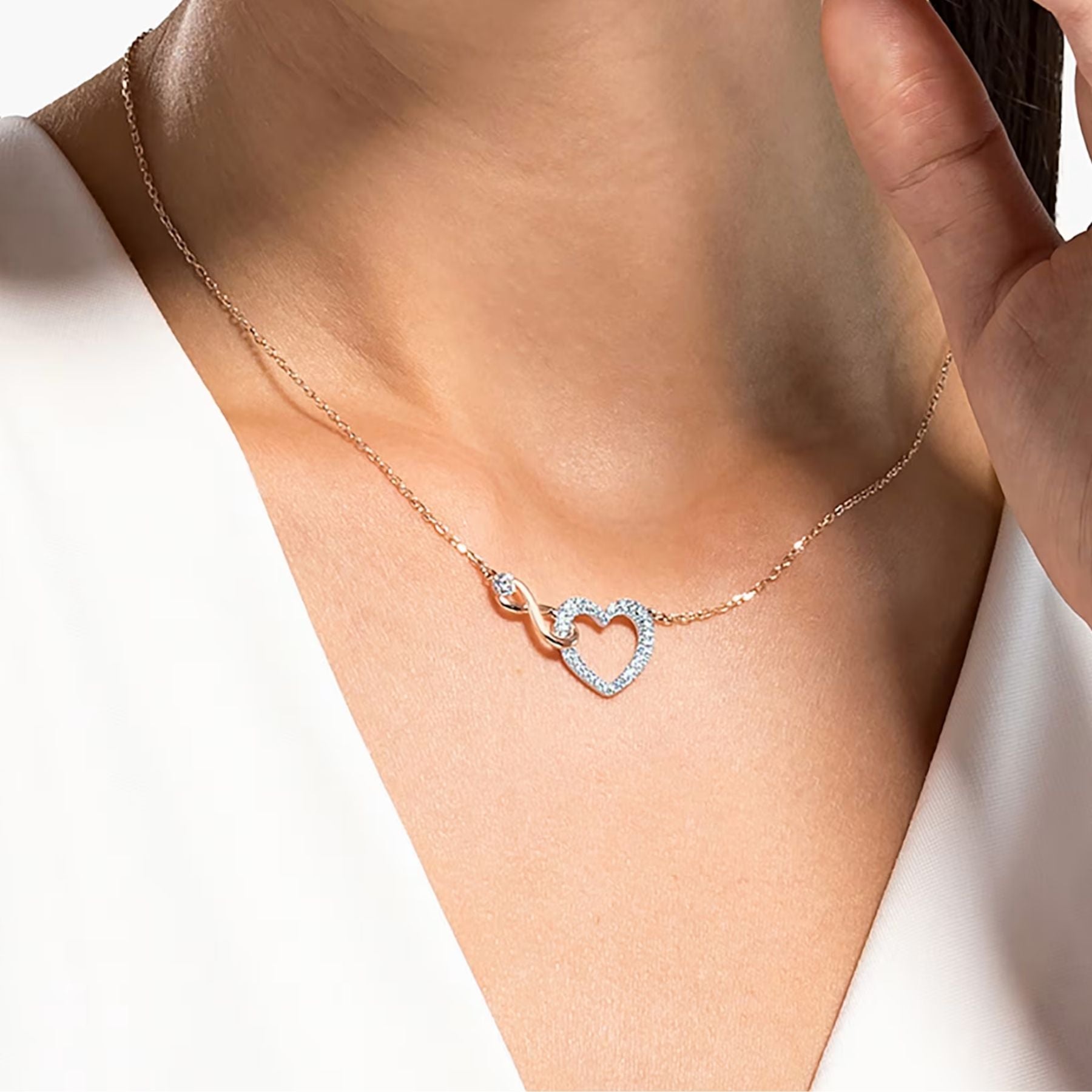 Swarovski kaksivärinen kaulakoru, jossa kristallein koristeltu sydämen ja ikuisuuden symbolia yhdistävä riipus rosekullan sävyssä